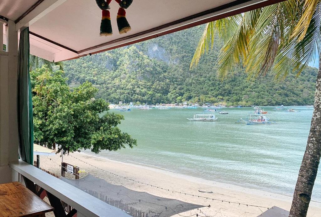 a view of the beach from a house window at RedDoorz @ Tandikan Beach Cottages in El Nido