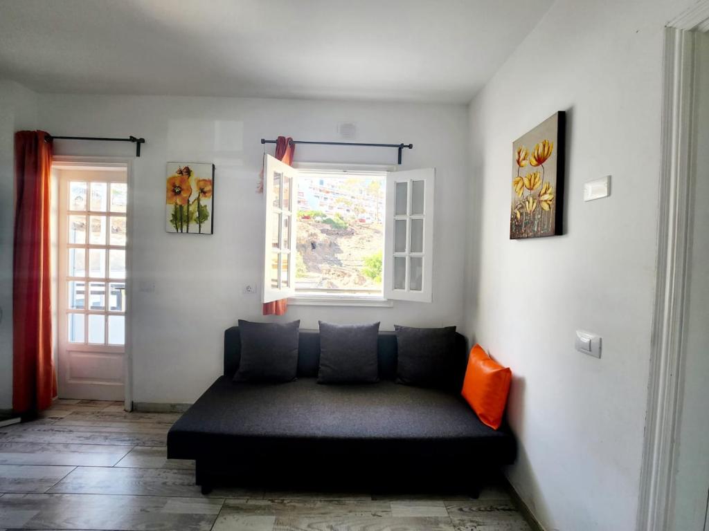 ロス・クリスティアーノスにあるLaikaの窓付きの客室で、黒いソファが備わります。