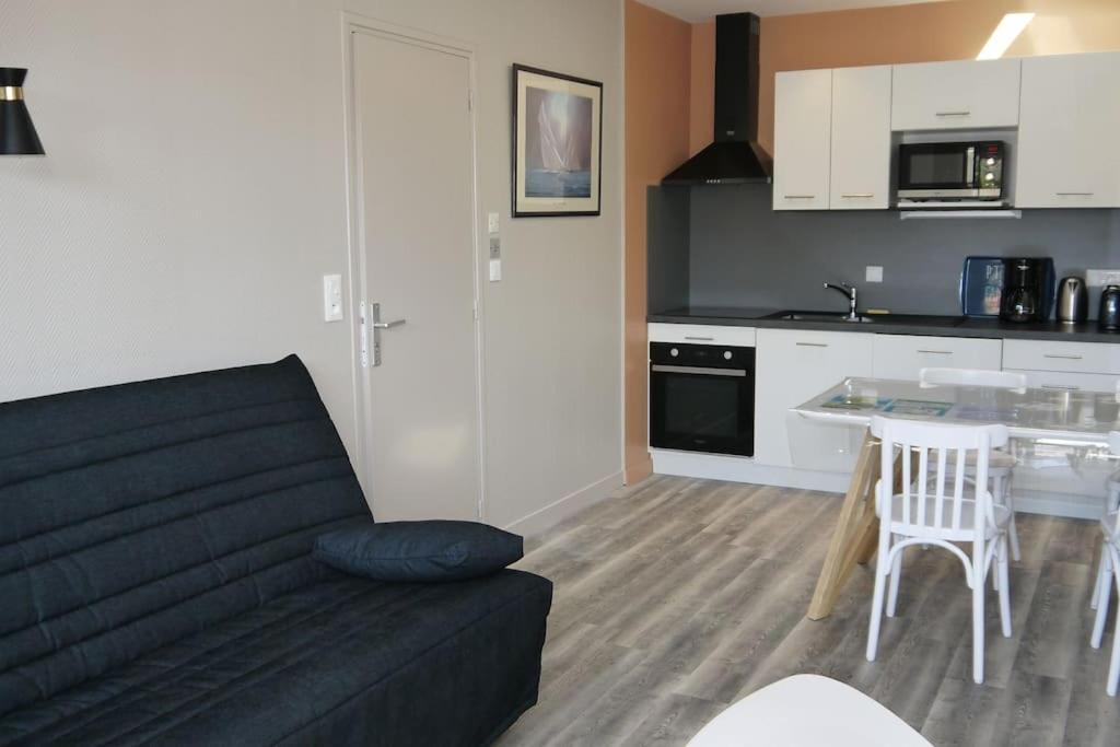 un salon avec un canapé et une cuisine dans l'établissement Appartement 4/6 pers accès plage direct : Batz, à La Bernerie-en-Retz