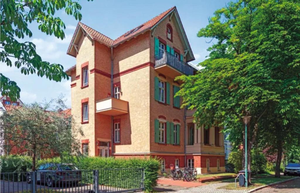 ポツダムにあるGründerzeitvilla in Potsdamの緑のシャッター付き窓のある大きなレンガ造りの建物