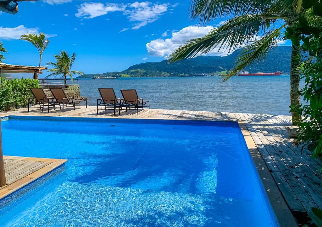a swimming pool with a view of the water at Pousada Vila das Velas in Ilhabela