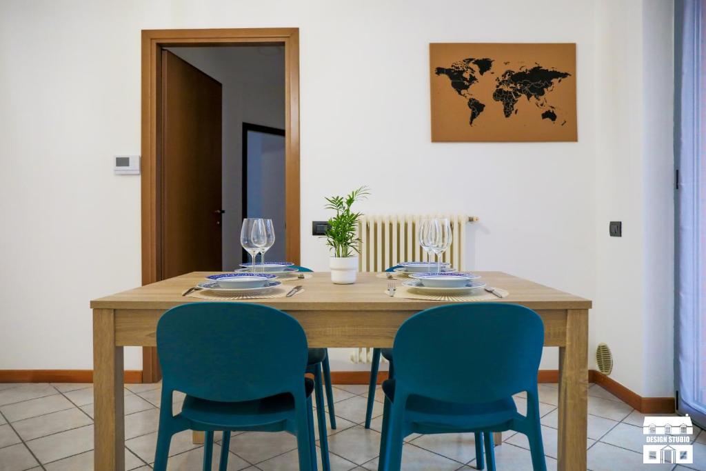 a dining room table with blue chairs and a world map on the wall at VELAHOUSE by Design Studio in Bellano