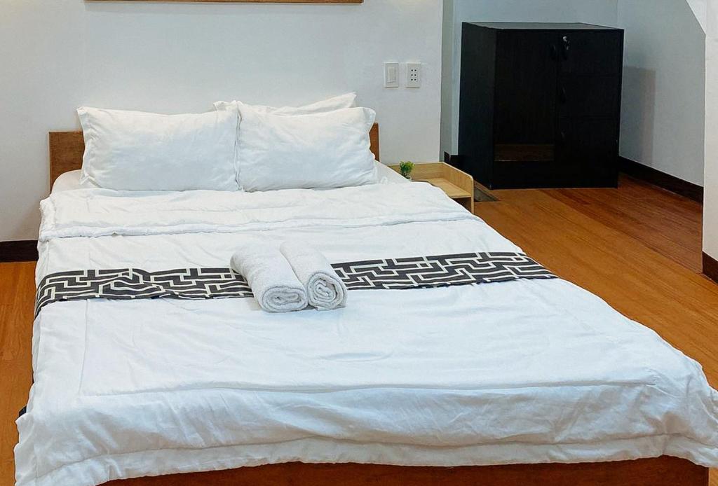 uma grande cama branca com duas toalhas em Stay Inn Station 1 Boracay by RedDoorz em Boracay