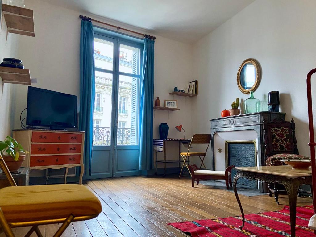 un salon avec une télévision et une cheminée dans l'établissement Le Blaisois, à Blois