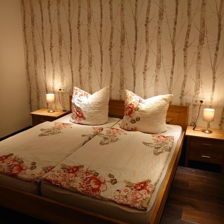 a bedroom with a bed with two lamps on tables at FeWo Elmo's Nest in Altenau