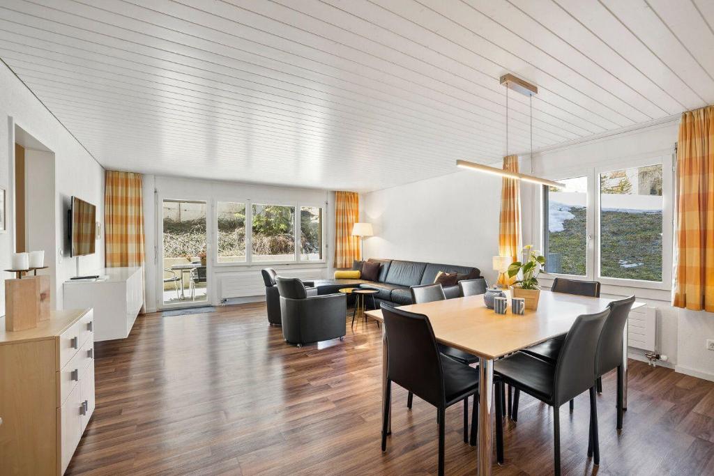 a dining room and living room with a table and chairs at Seestrasse 3, Whg 104 in Lenzerheide