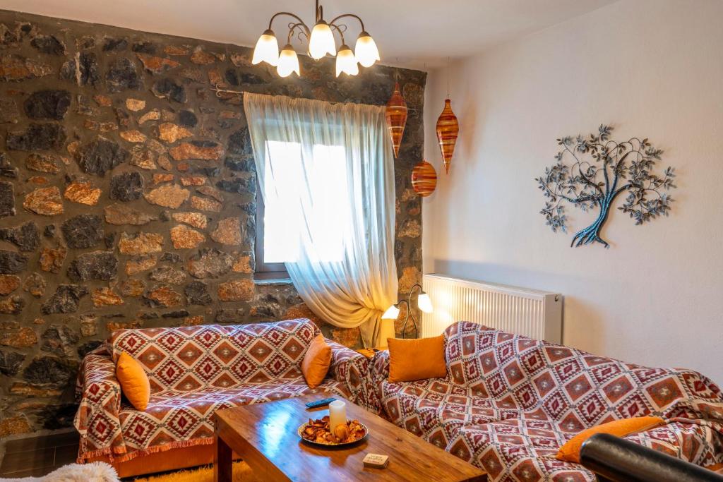 een woonkamer met een bank en een tafel bij G & M Stone House in Palaios Agios Athanasios