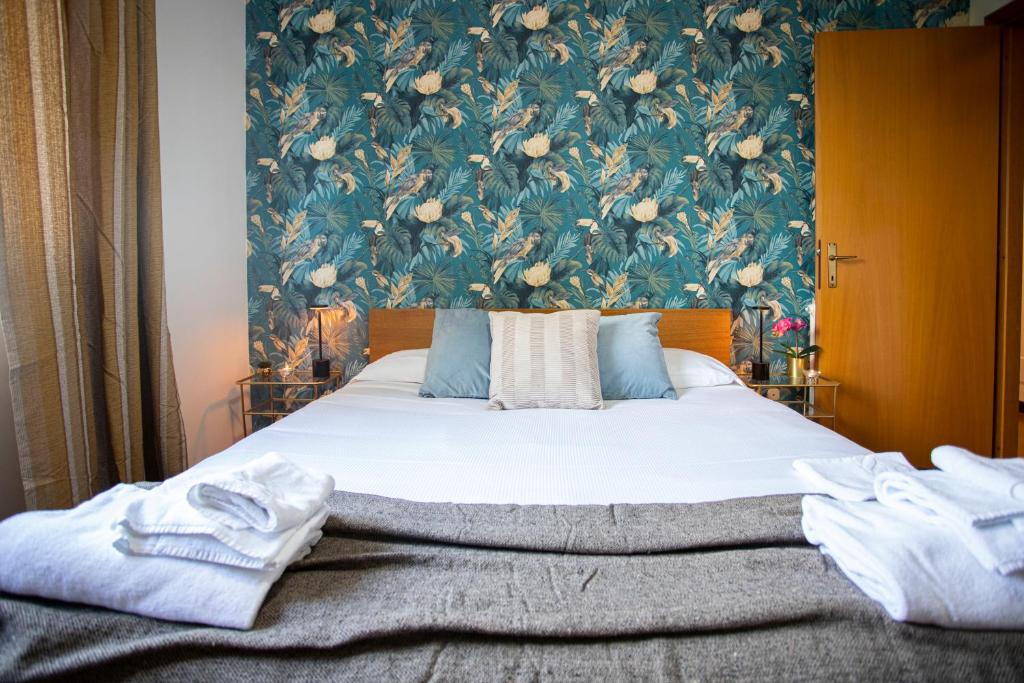 a bedroom with a bed with a floral wallpaper at Emilia - Elegant and Modern Apartment in Rome