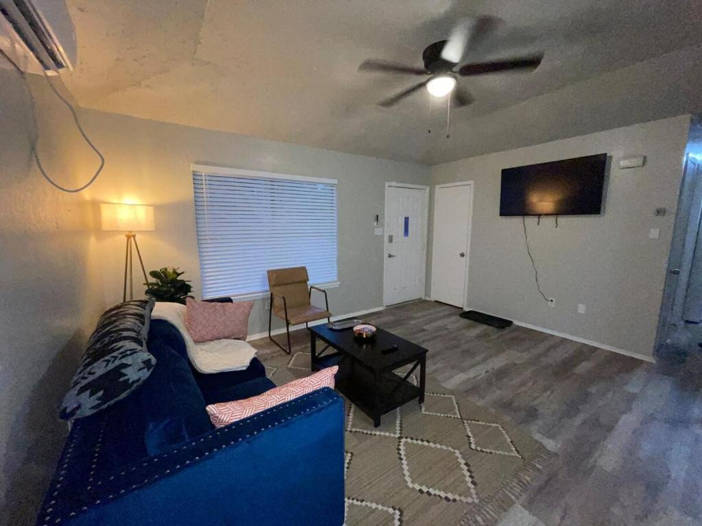 a living room with a blue couch and a ceiling fan at Tendayis Paradise - Work Crew Lodging in Abilene