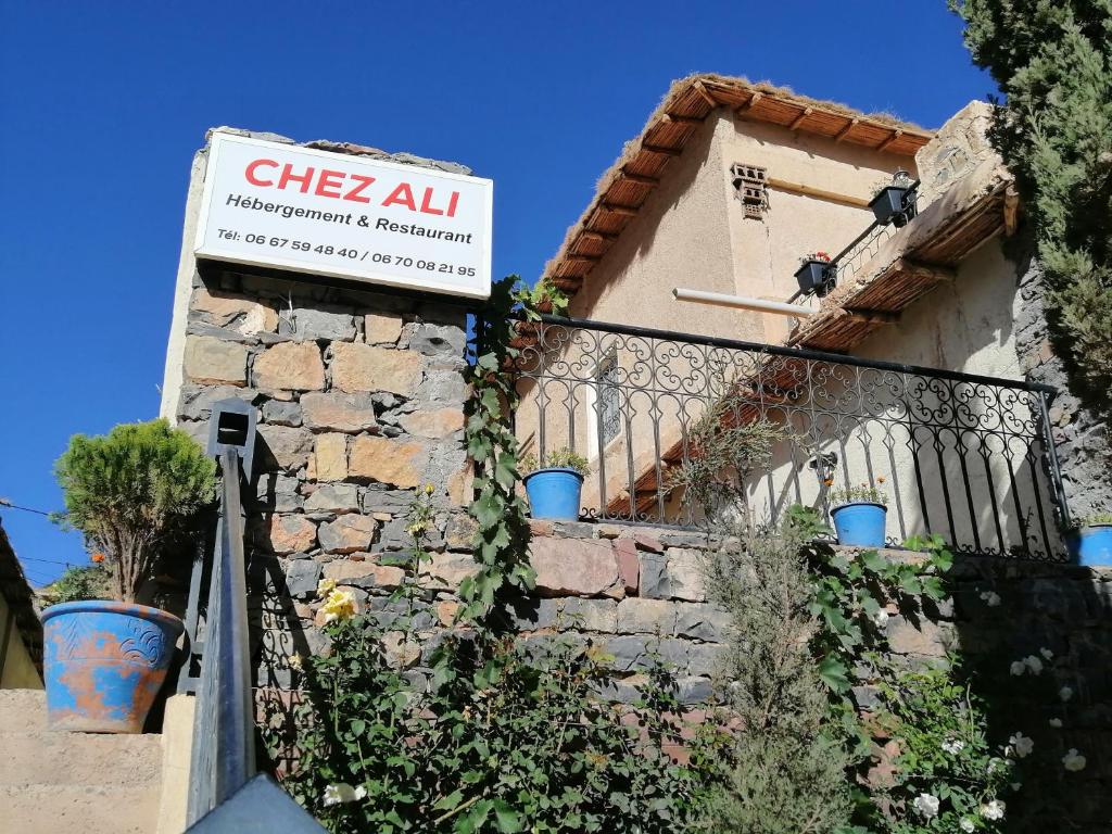 a sign on the side of a building with plants at Gite chez Ali Agouti Maison Berbère in Idoukaln