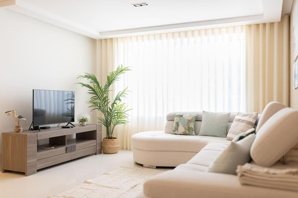 a living room with a white couch and a tv at Mifi Beach Luxury Duplex by MP in Vila Nova de Gaia