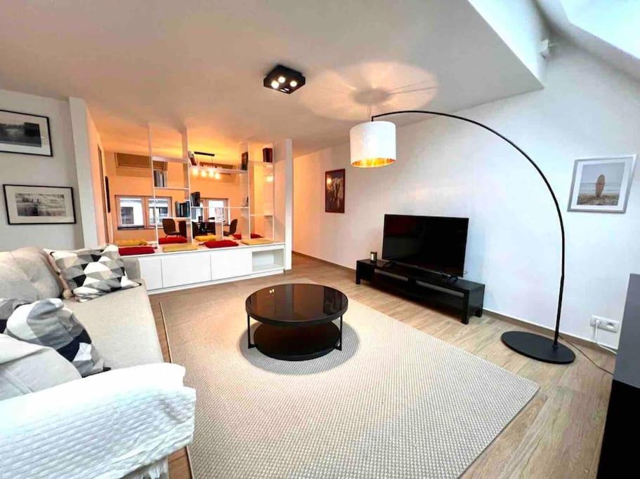 a living room with a couch and a table at Le contemporain - Plein centre, place du Marché in Liège