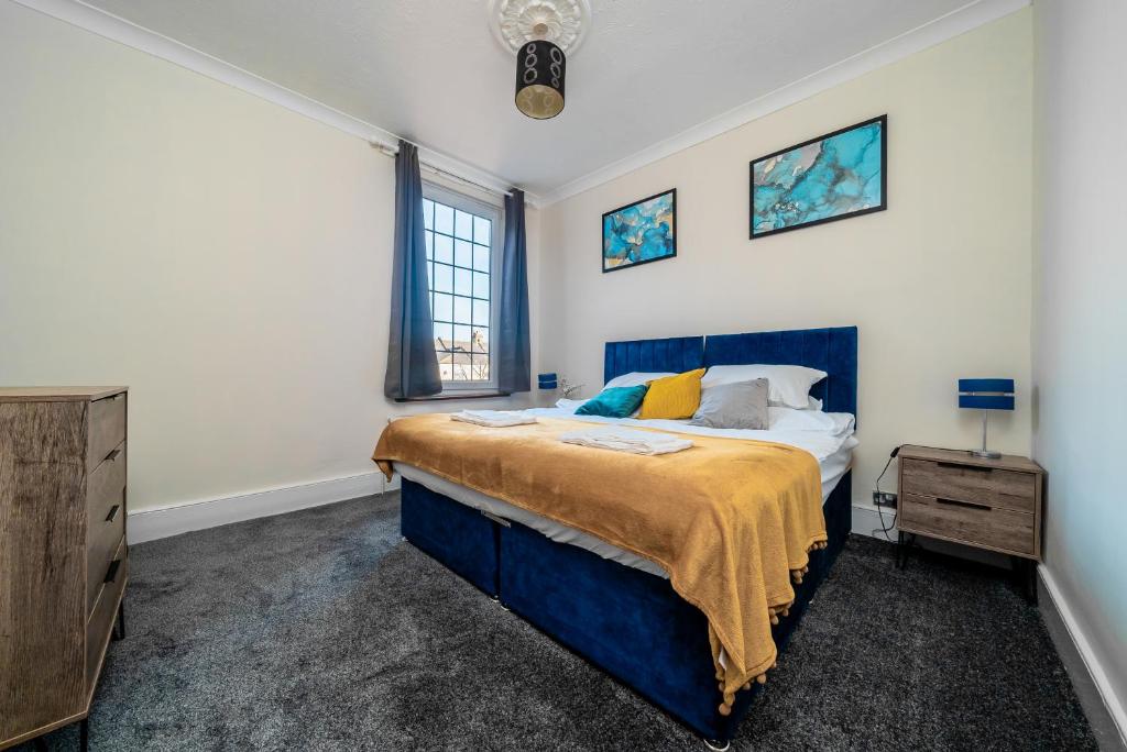 a bedroom with a blue bed and a dresser at Uksas Stunning one bedroom Flat Free Parking in London