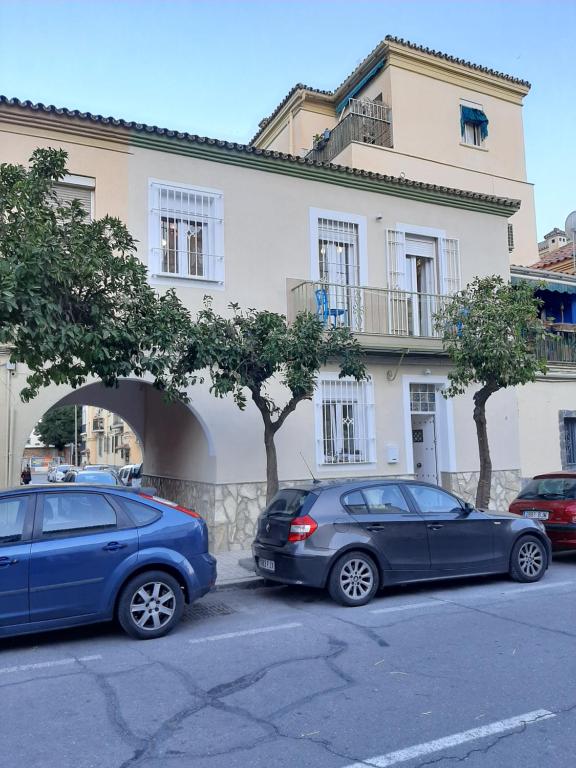 deux voitures garées devant un bâtiment dans l'établissement Casa El Capitán, à Malaga