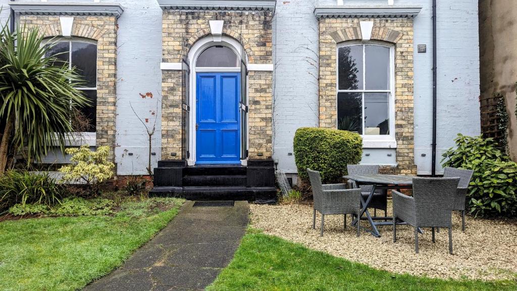 a blue door on a house with a table and chairs at Spacious home, by Headingley Stadium, LGI, Leeds Arena, and the University of Leeds in Headingley