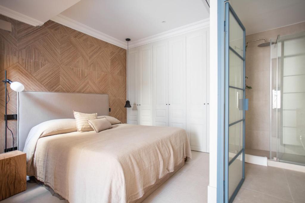 Schlafzimmer mit einem weißen Bett und einer Glastür in der Unterkunft SEISSTA Madrid Centro "Remodelado" in Madrid