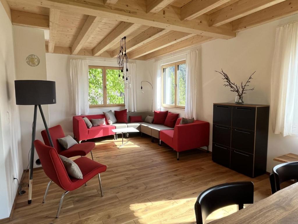 a living room with red chairs and a couch at Ferienhaus Baiersbronn LUG INS TAL in Baiersbronn