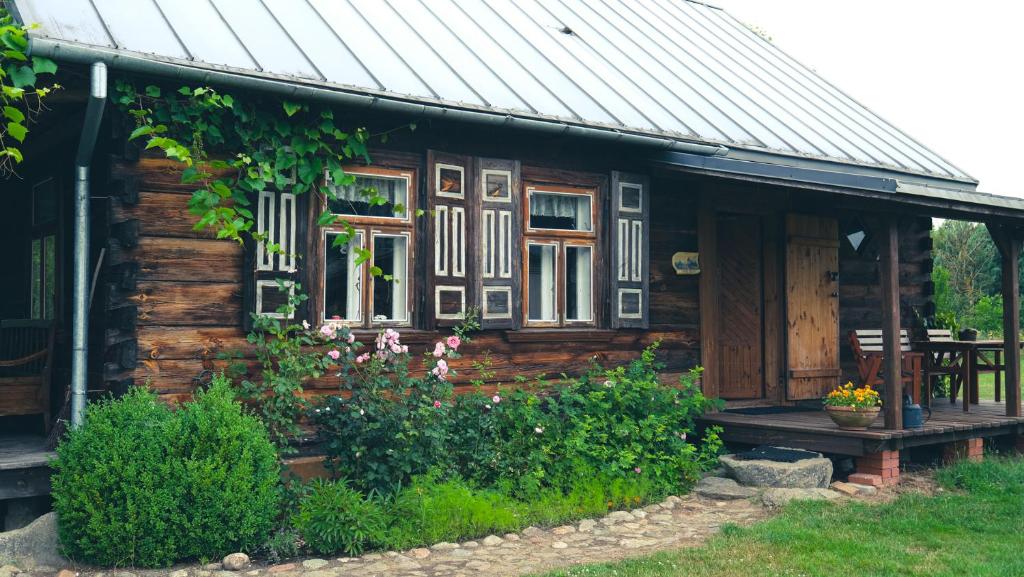 uma casa de madeira com janelas e um alpendre em Uroczysko Grabowiec em Grabowiec
