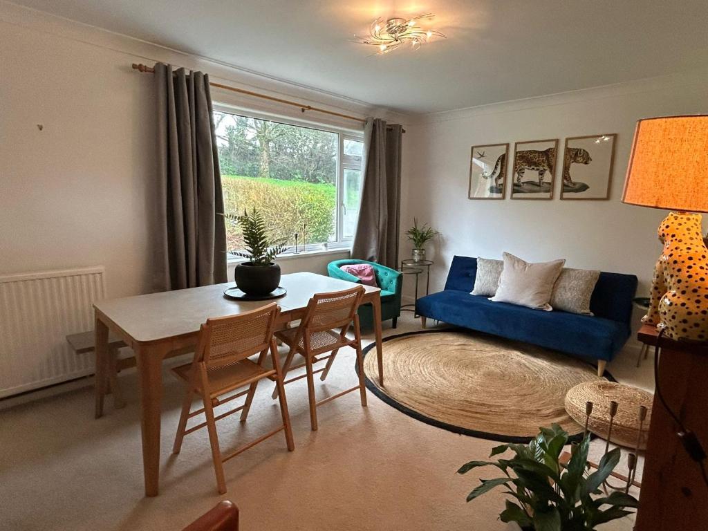 a living room with a table and a blue couch at Entire 4-bed, near town centre in Falmouth