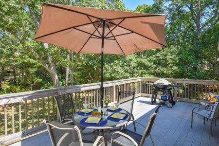 een patio met een tafel en een parasol op een terras bij Quiet Location Near Oceanside Beaches in Eastham