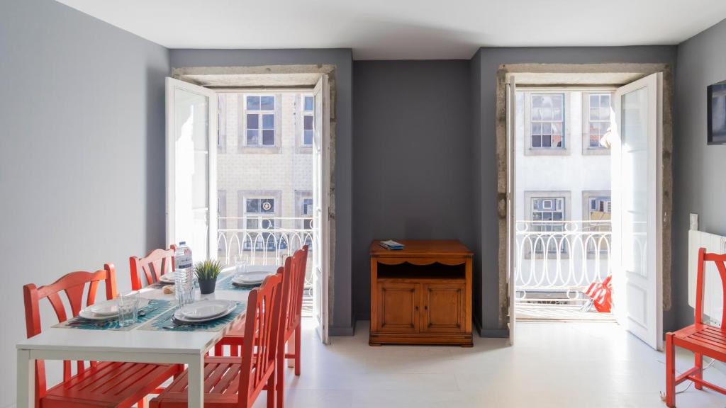 een eetkamer met een witte tafel en rode stoelen bij Bridge D Luis II Apartment by Unique Hosts in Porto