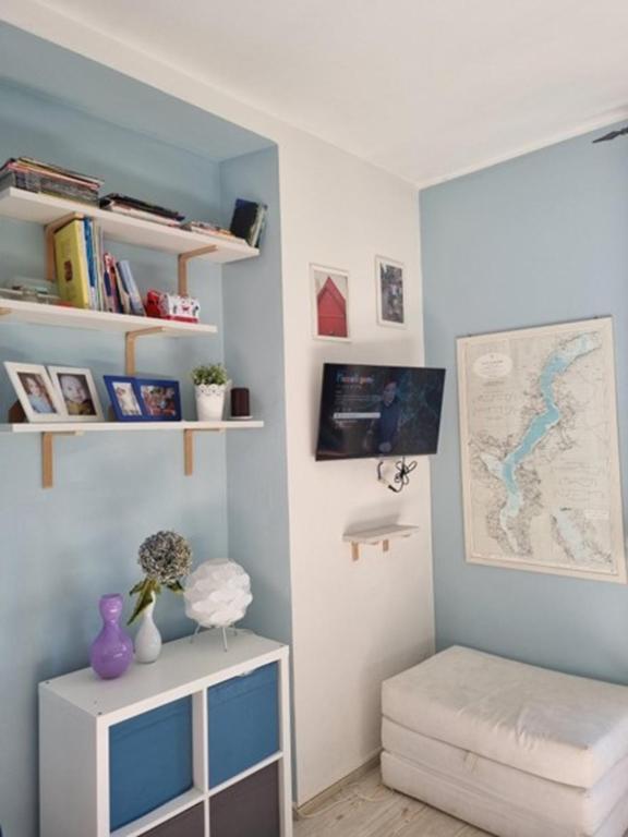 a room with a blue wall with a desk and a shelf at Apartment camelie with private beach in Baveno