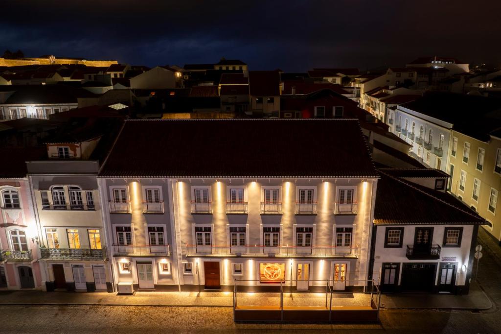 un gran edificio blanco con luces encendidas por la noche en Açores Autêntico Boutique Hotel en Angra do Heroísmo