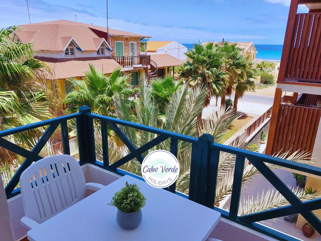 a balcony with a table and chairs and the beach at Branco Sea Holiday Apartments in Santa Maria