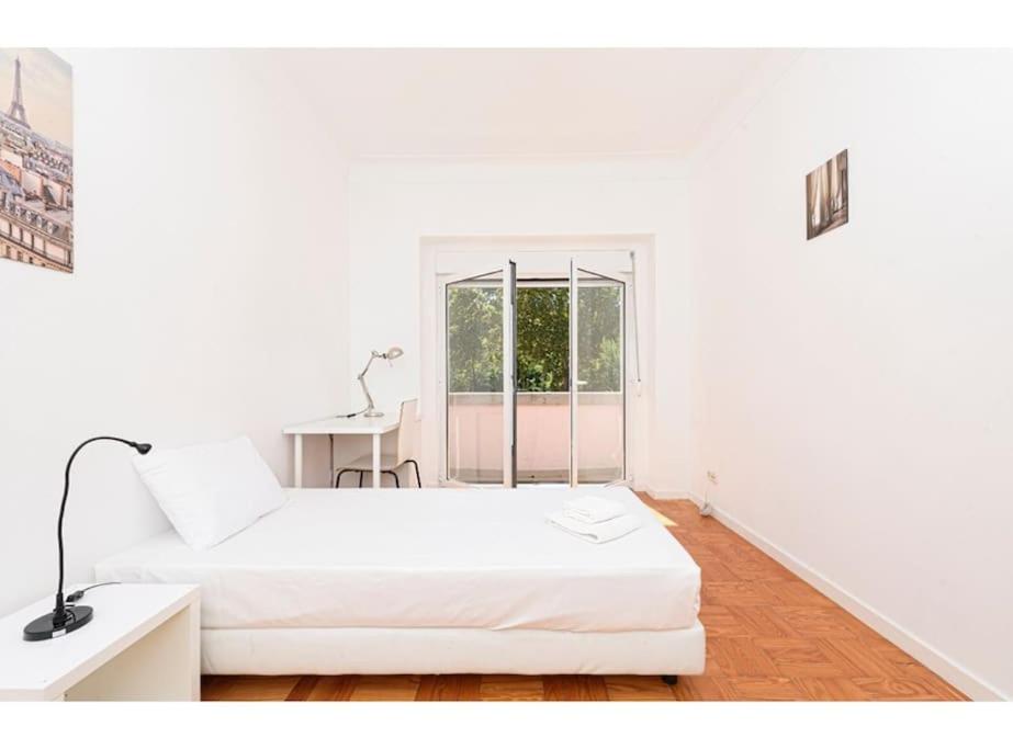 a white room with two beds and a window at HOUZE_Central Lisbon 4 room flat in Lisbon
