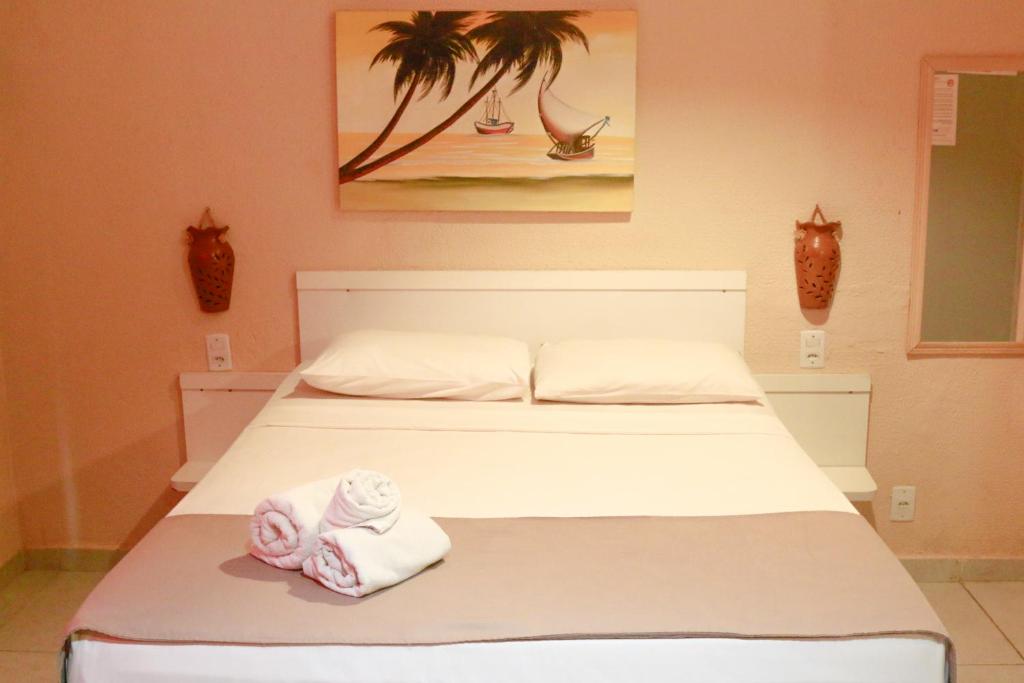 a bedroom with a bed with towels on it at El Dorado Hotel Fortaleza in Fortaleza