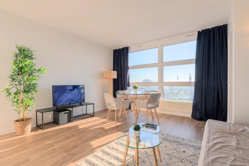 un salon avec une table et une télévision dans l'établissement Lille Gare - 2 pers incredible view on Lille !, à Lille