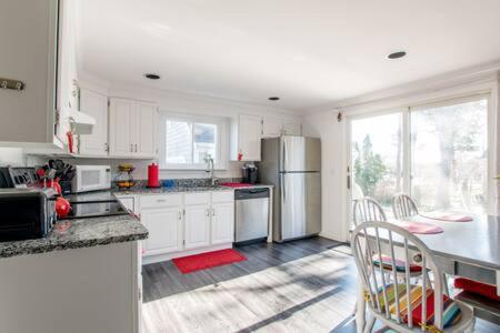a kitchen with white cabinets and a table and chairs at Central AC Close to Beach Dog Friendly! in Chatham