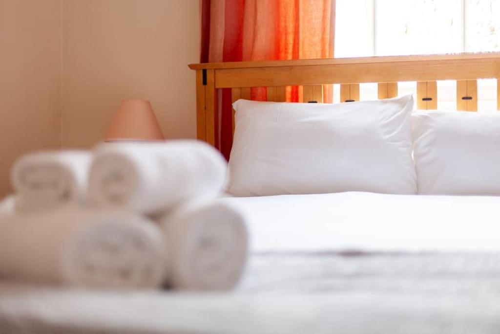 Una cama con almohadas blancas y una lámpara. en Spacious & Central 3-bed flat by popular Waterloo! en Londres