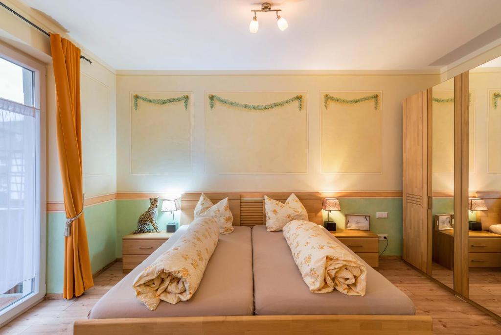 a bedroom with a bed with pillows on it at Schusterjunge Aparthotel A1 in Sasbachwalden
