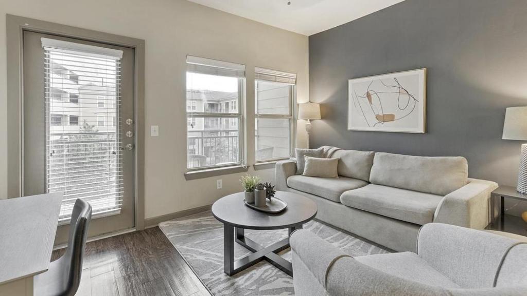 a living room with a couch and a table at Landing Modern Apartment with Amazing Amenities (ID1721X12) in Fort Worth