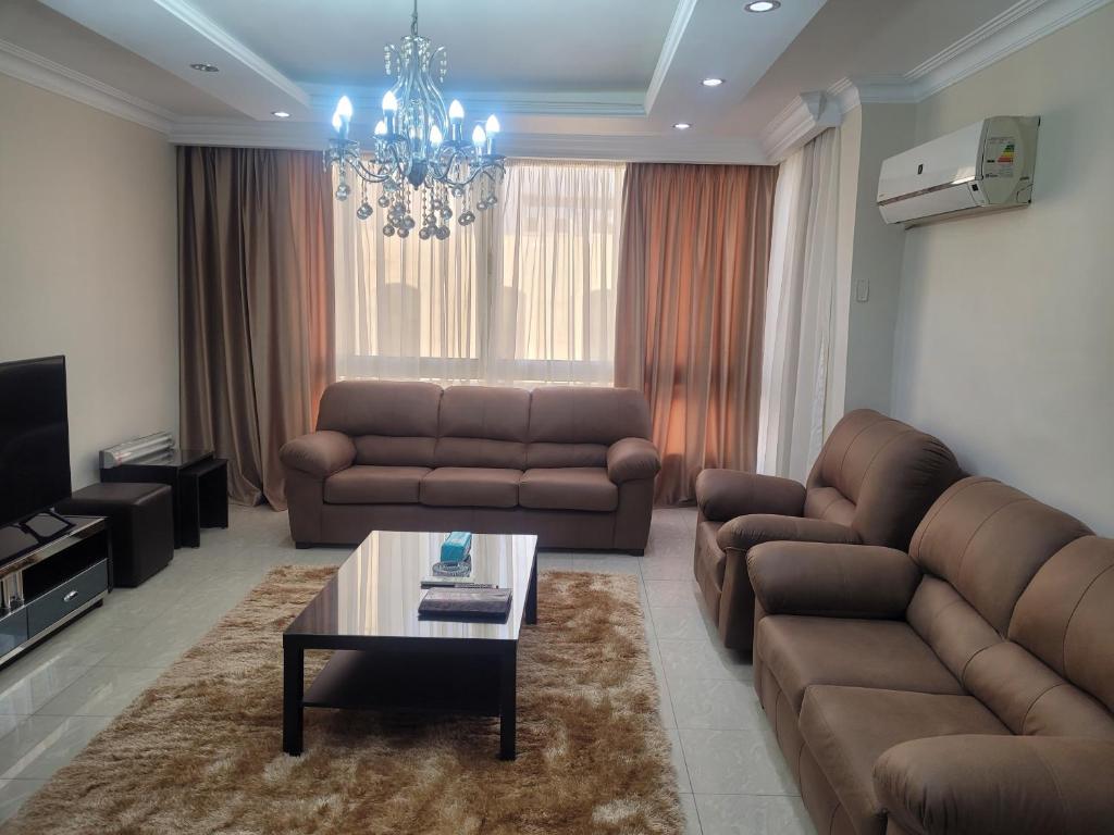 a living room with two couches and a coffee table at Logistic Apartment in Cairo