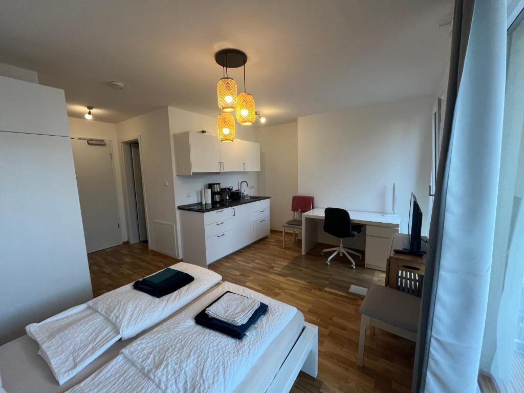 een slaapkamer met 2 bedden, een bureau en een keuken bij New Business Apartment Nr23 in Dresden