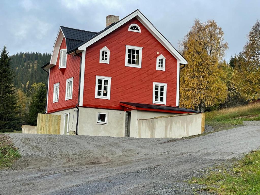 a large red house with a garage on a dirt road at Solbergshyllan in Åre