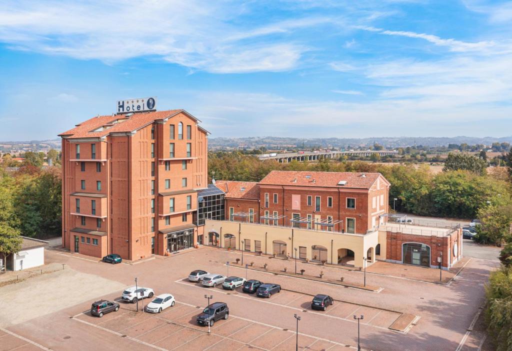 a building with cars parked in a parking lot at Hotel Ristorante Al Mulino in Alessandria