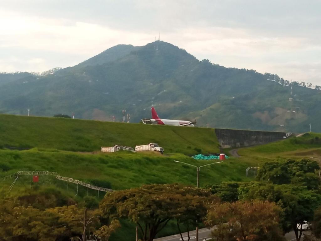 an airplane on a hill with a mountain in the background at Hospédate cerca al aeropuerto Matecaña in Pereira