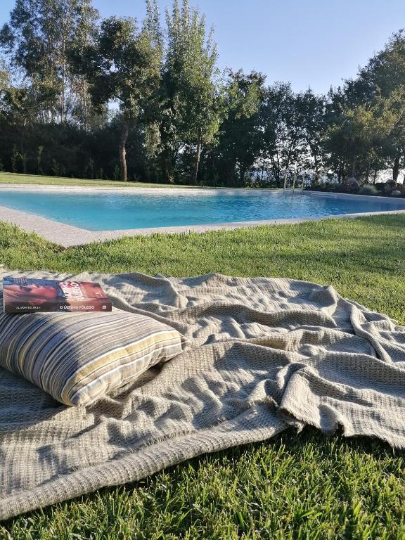 a blanket laying on the grass in the field at Casa de Férias do Parque da Peneda 2 in Vila Verde