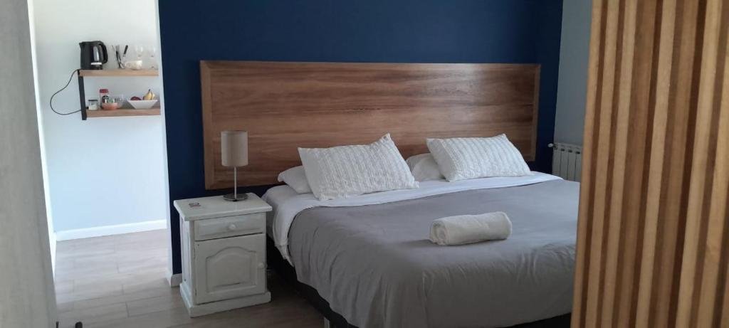 een slaapkamer met een groot bed met een houten hoofdeinde bij Cantal Bed & Breakfast in El Durazno