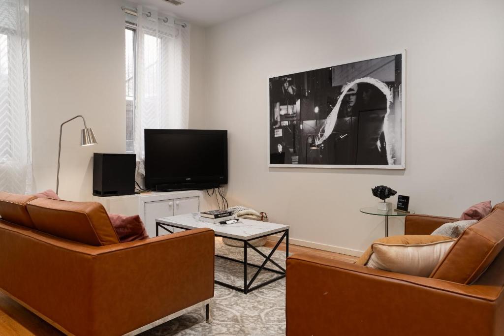 a living room with two chairs and a flat screen tv at Flexhome Wicker Park 2BR P1 - READ INFO in Chicago