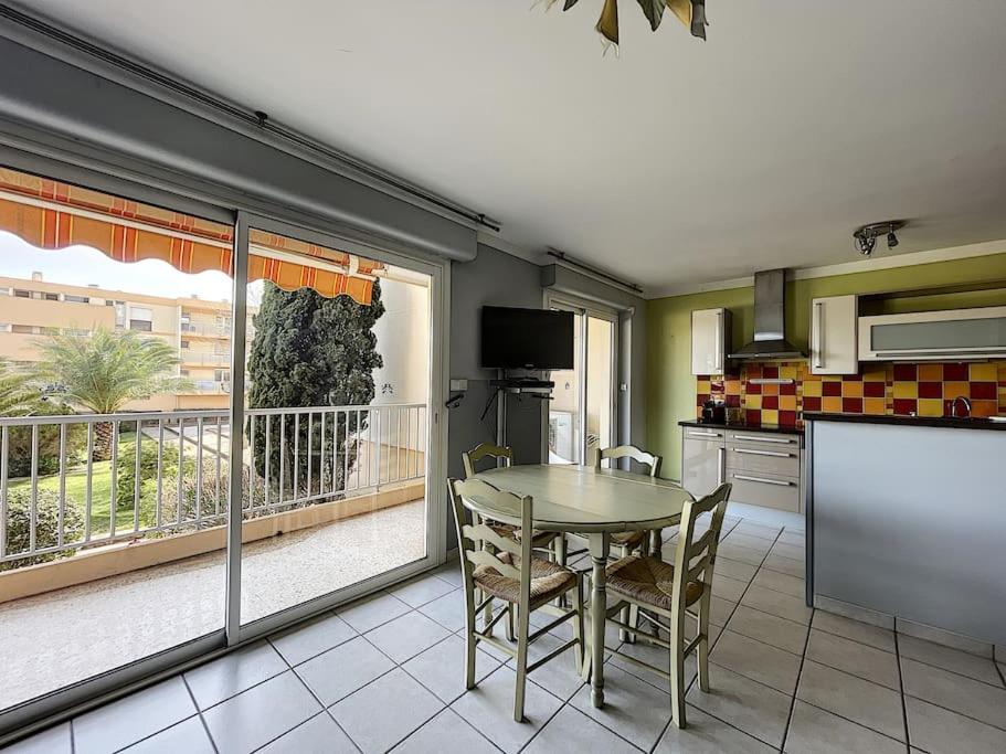 a kitchen with a table and a balcony at Nice family apartment close to the beach in Le Lavandou