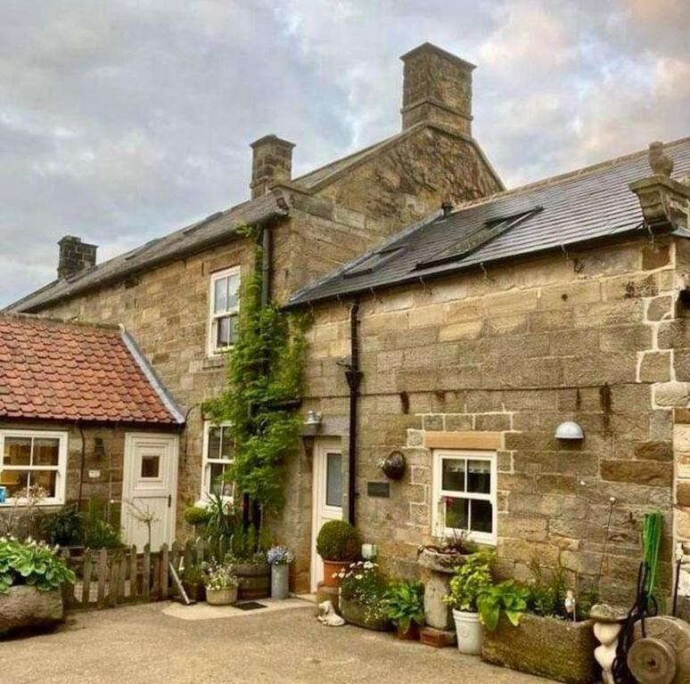 una antigua casa de piedra con techo en The Old Tackroom, luxury Barn. en Sleights