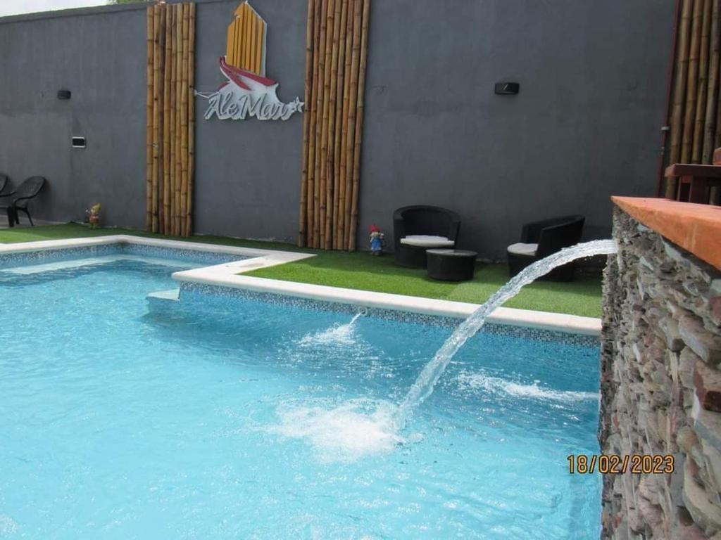 a large swimming pool with a water fountain at Alemar Termas Hotel in Termas de Río Hondo