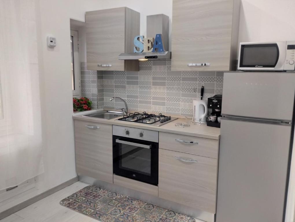 una cucina con frigorifero bianco e lavandino di Casa Vacanze Andrea la tua base per visitare il mare delle Cinque Terre a La Spezia