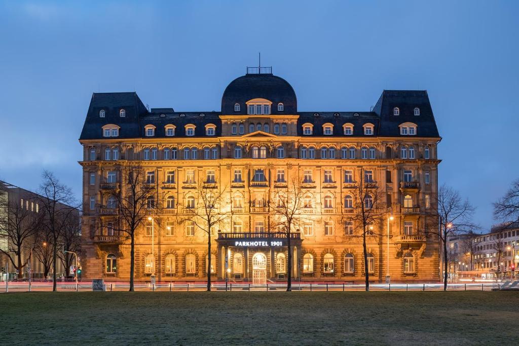un gran edificio con luces delante en Parkhotel 1901 Mannheim, en Mannheim