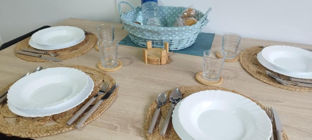 a table with white plates and silverware on it at Puerto Pesquero de Cariño in Cariño