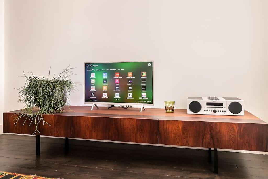 a desk with a television and a radio on it at Bohemian Residence in Maastricht